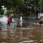 बाढ़ के पानी में लोग